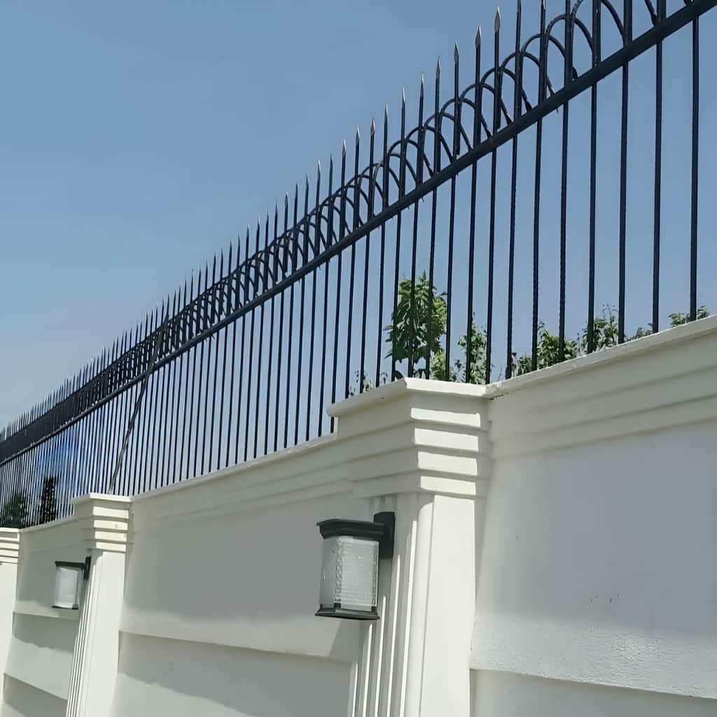 حفاظ سرنیزه ای 3 حفاظ سرنیزه ای مشکی نصب شده روی دیوار باغ