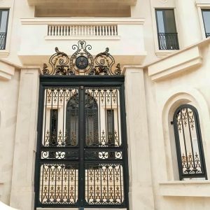 درب ویلا مدرن با قاب فلزی تیره کنار نمای سنگی روشن