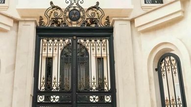 درب ویلا مدرن با قاب فلزی تیره کنار نمای سنگی روشن